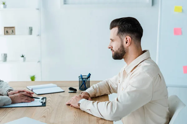 Ausgeschnittener Blick auf Personalvermittler in der Nähe eines gutaussehenden bärtigen Mitarbeiters — Stockfoto