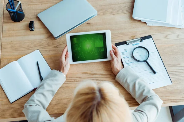 Top view of recruiter holding digital tablet with green charts and graphs on screen — Stock Photo