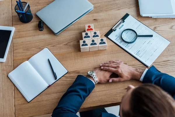 Cropped view of man with clenched hands near wooden cubes — Stock Photo