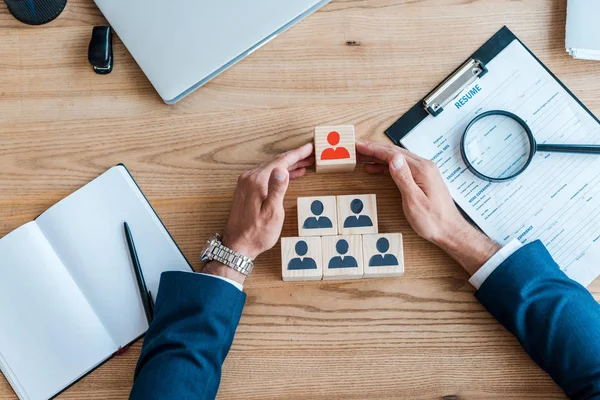 Top view of recruiter near wooden cubes and clipboard on table — Stock Photo