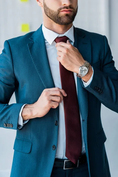 Vista recortada del reclutador barbudo tocando corbata en la oficina - foto de stock