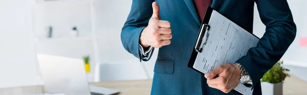 Panoramic shot of recruiter standing and holding clipboard with resume letters while showing thumb up — Stock Photo