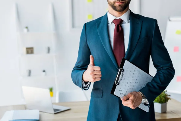 Cropped view of recruiter standing and holding clipboard with resume letters while showing thumb up — Stock Photo