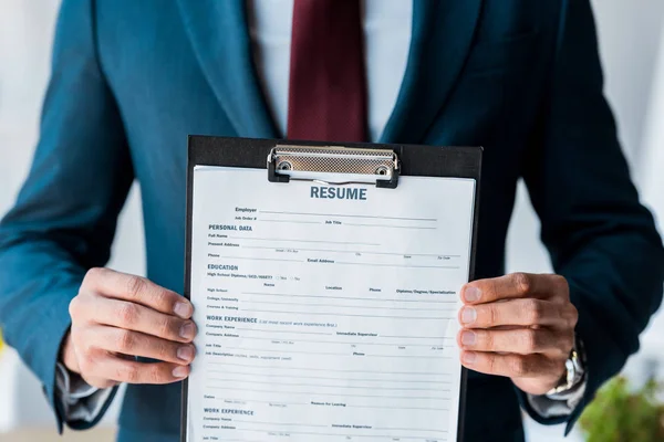 Selective focus of clipboard with resume lettering in hands of man — Stock Photo