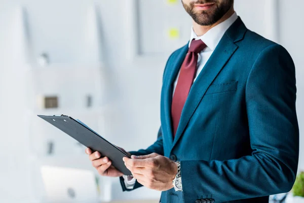 Vista recortada del reclutador barbudo y feliz sujetando portapapeles — Stock Photo