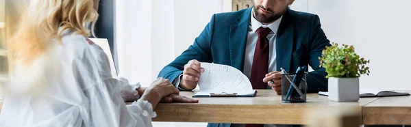 Panoramaaufnahme eines bärtigen Personalvermittlers, der neben einer blonden Angestellten sitzt — Stockfoto