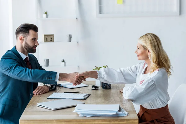 Foco seletivo de recrutador bonito e atraente funcionário apertando as mãos — Fotografia de Stock