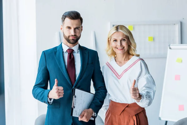 Beau recruteur et femme blonde montrant pouces au bureau — Photo de stock