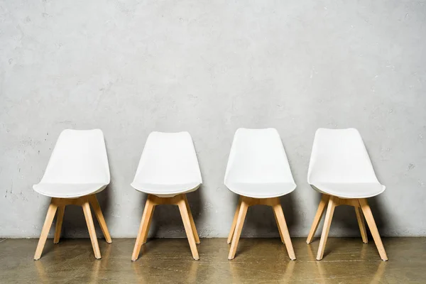 Chaises blanches près du mur de béton gris avec espace de copie dans le bureau — Photo de stock