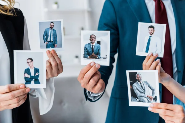 Abgeschnittene Ansicht von Personalvermittlern, die Fotos berühren, während sie im Büro stehen — Stockfoto