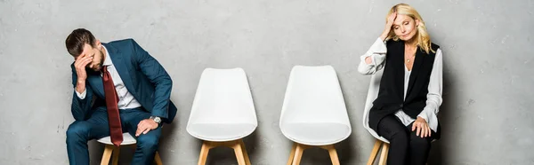 Tiro panorâmico de funcionários cansados esperando entrevista de emprego e sentado em cadeiras — Fotografia de Stock