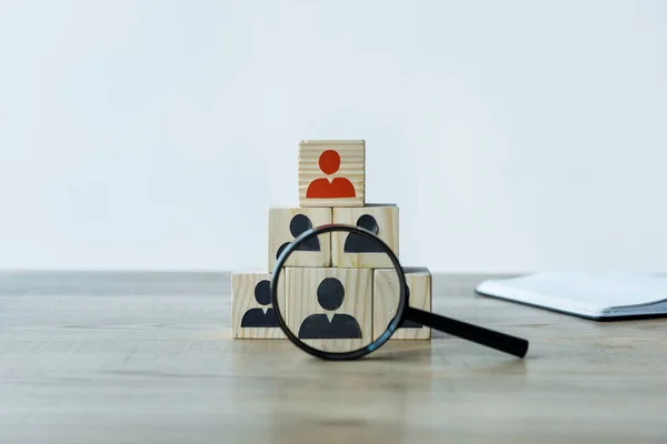 Magnifying glass near wooden cubes on desk in office — Stock Photo