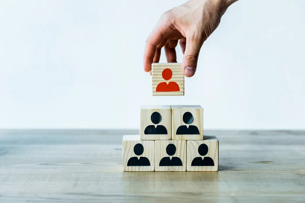 Cropped view of man holding wooden cube near wooden desk — Stock Photo