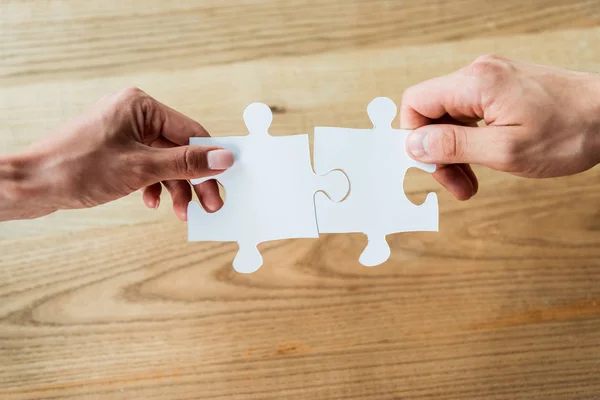 Cropped view of african american woman and man holding jigsaw puzzle pieces — Stock Photo