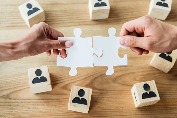 Top view of african american woman and man holding jigsaw puzzle pieces near wooden cubes — Stock Photo