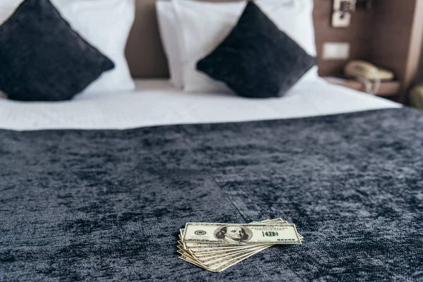 Notas de dólar na cama com almofadas no quarto de hotel — Fotografia de Stock