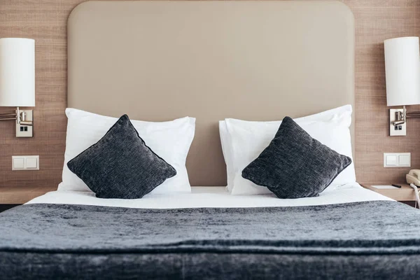 Bed with pillows and cushions in cozy hotel room — Stock Photo