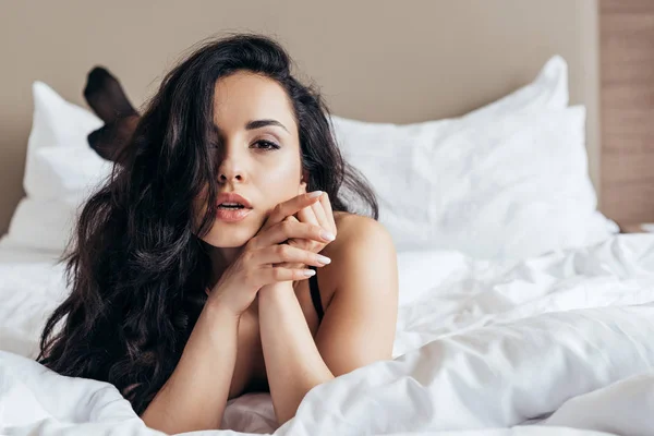 Frontansicht der sexy unbekleideten jungen Frau, die im Bett im Schlafzimmer liegt — Stockfoto
