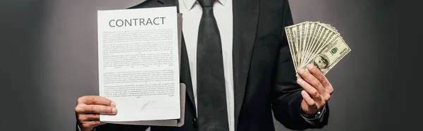 Cropped view of african american businessman showing contract and holding cash on dark background, panoramic shot — Stock Photo