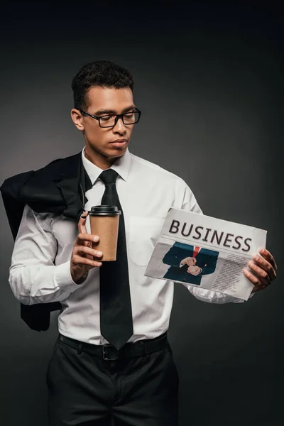 Africano americano empresário segurando blazer, copo de papel e jornal de negócios no fundo escuro — Fotografia de Stock