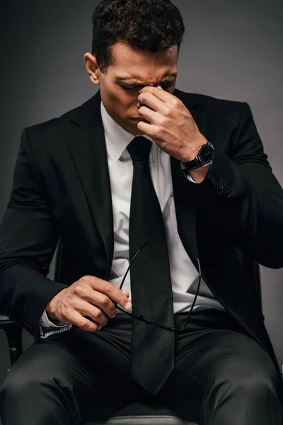 Tired african american businessman in suit rubbing his eyes — Stock Photo