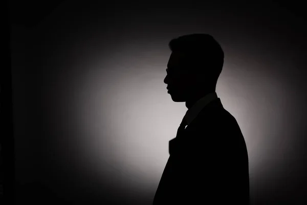 Side view of black silhouette of businessman with back light — Stock Photo