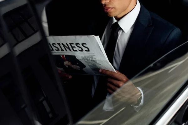 Visão cortada do empresário afro-americano lendo jornal de negócios em carro — Fotografia de Stock