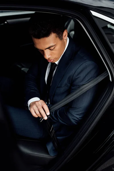 Afroamericano uomo d'affari fissaggio cintura di sicurezza in auto — Foto stock