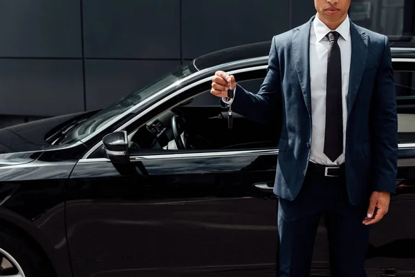 Vue recadrée de l'homme afro-américain en costume tenant clé de voiture — Photo de stock