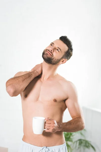 Hombre guapo sin camisa sosteniendo la taza de café en casa por la mañana - foto de stock