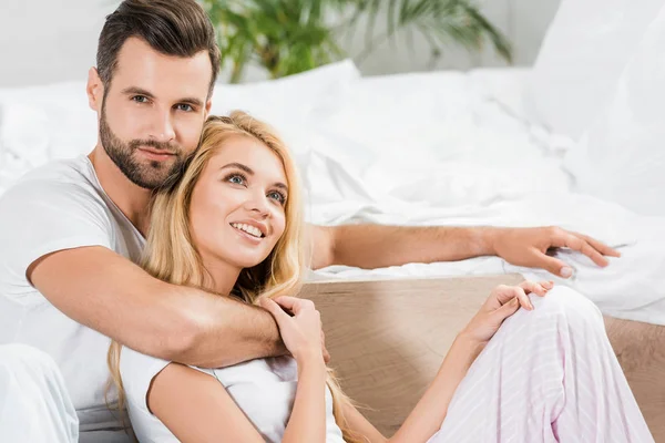Beautiful couple hugging near bed at home — Stock Photo