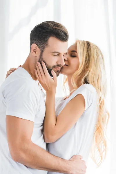 Woman kissing and embracing man at home in morning — Stock Photo