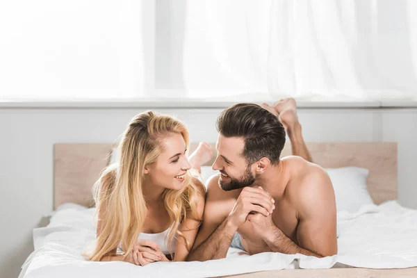 Bella coppia romantica che riposa sul letto e sorride a casa — Foto stock