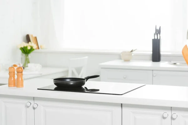 Modern kitchen with white counter, cooker and frying pan — Stock Photo