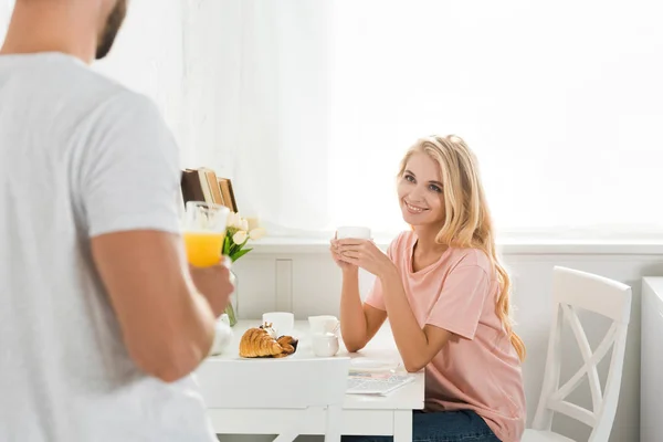 Пара завтракает за кухонным столом утром — стоковое фото