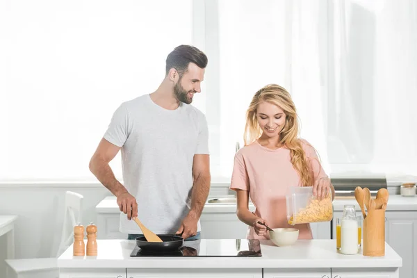 Красива пара готує сніданок разом на кухні — стокове фото