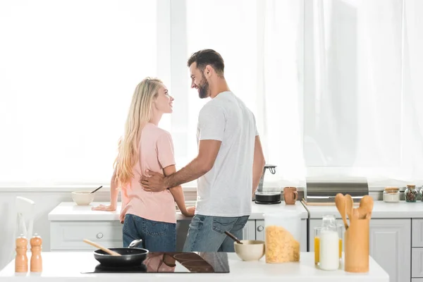 Vue arrière du beau couple pendant le petit déjeuner à la cuisine — Photo de stock