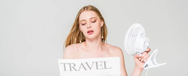 Panoramaaufnahme einer jungen Frau mit Elektroventilator und Reisezeitung, die unter Hitze isoliert auf grau leidet — Stockfoto