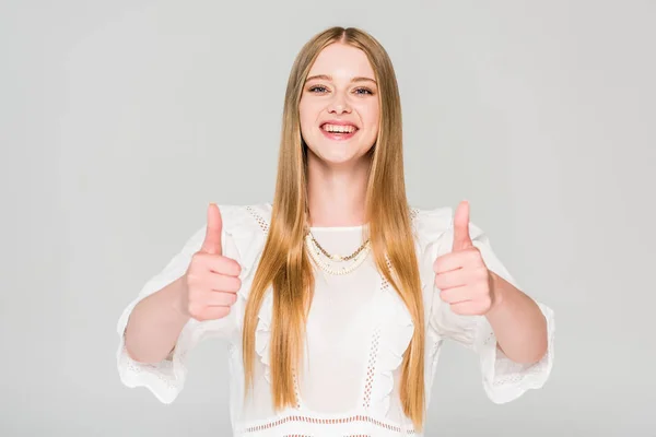 Bella ragazza sorridente mostrando pollici in su isolato su grigio — Foto stock