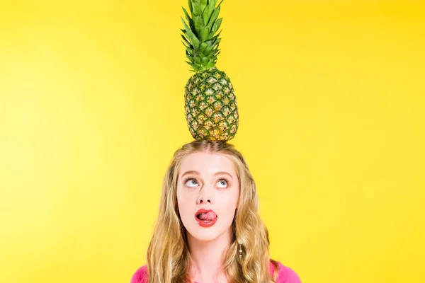 Belle fille posant avec ananas sur la tête et la langue collante sur Isolé Sur jaune — Photo de stock