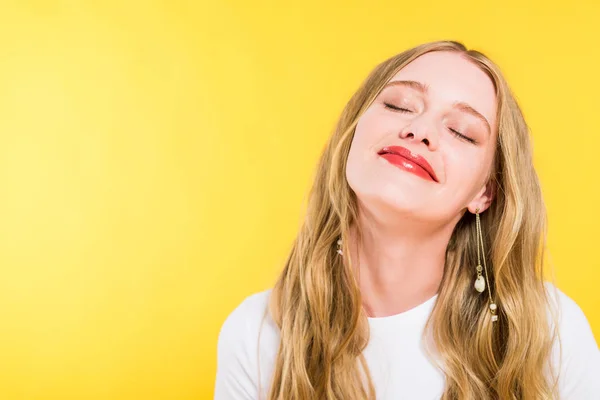 Schöne blonde junge Frau mit geschlossenen Augen isoliert auf gelb — Stockfoto