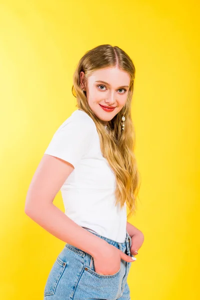 Beautiful blonde young woman with Hands In Pockets posing Isolated On yellow — Stock Photo