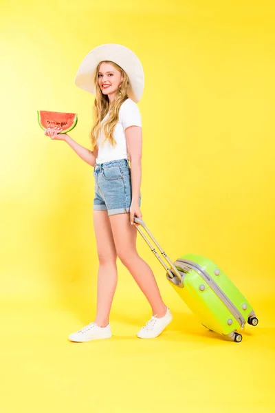 Beautiful girl with suitcase and watermelon On yellow — Stock Photo