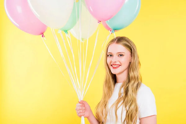 Beautiful girl with balloons looking at camera On yellow — Stock Photo