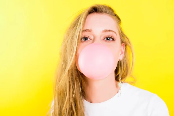 Bela menina soprando chiclete isolado no amarelo — Fotografia de Stock