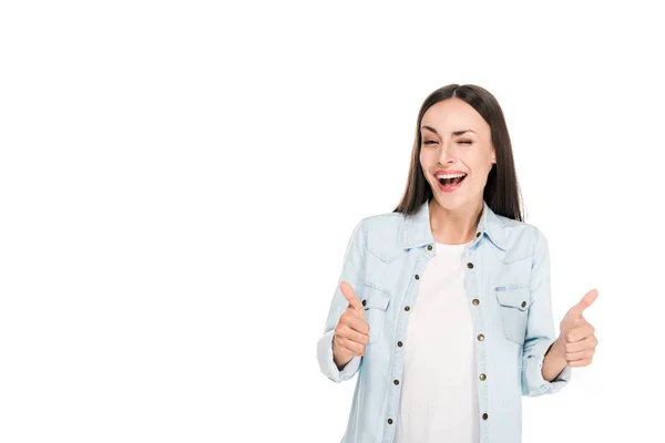 Happy winking brunette woman showing thumbs up isolated on white — Stock Photo