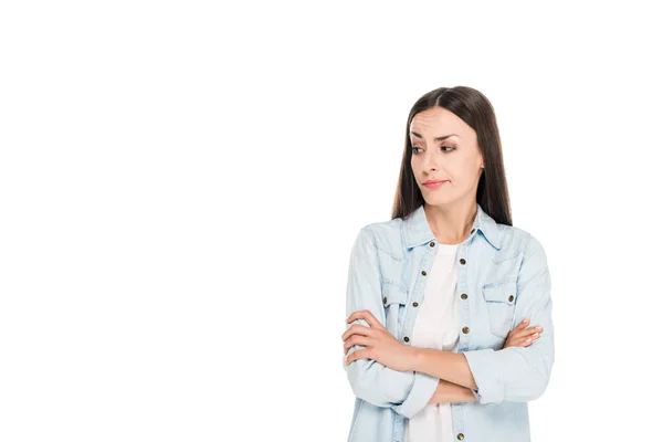Skeptical brunette woman standing with crossed arms isolated on white — Stock Photo