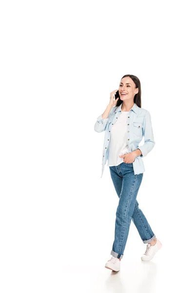 Jeune femme souriante marchant et parlant sur smartphone isolé sur blanc — Photo de stock