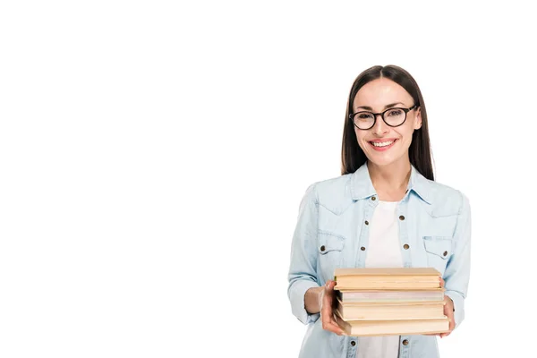 Sorridente ragazza bruna in occhiali in giacca di jeans con libri isolati su bianco — Foto stock