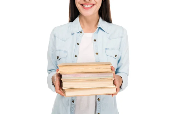 Corte vista de sorrindo morena menina em jaqueta de ganga segurando livros isolados no branco — Fotografia de Stock